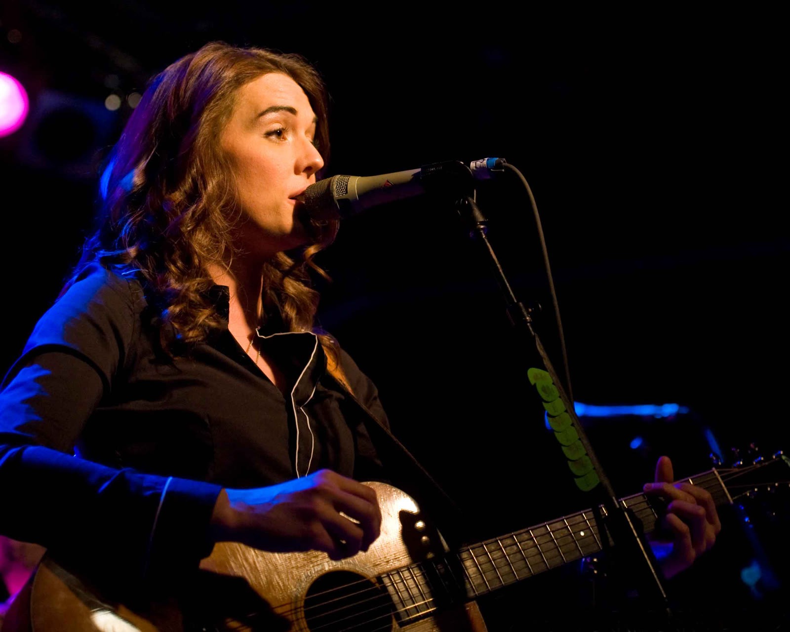 Brandi Carlile singing and playing guitar on stage in Seattle