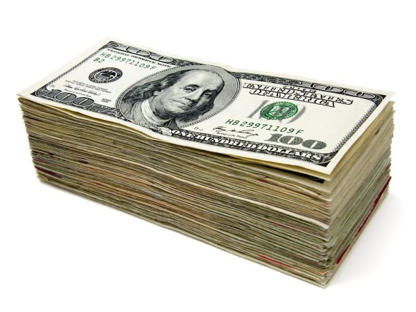 Stack of hundred-dollar bills illustrating how celebrity net worth is calculated from cash and assets
