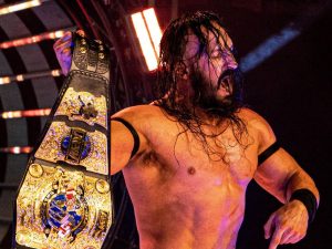 AEW star Pac holding a championship belt in the ring, June 2022