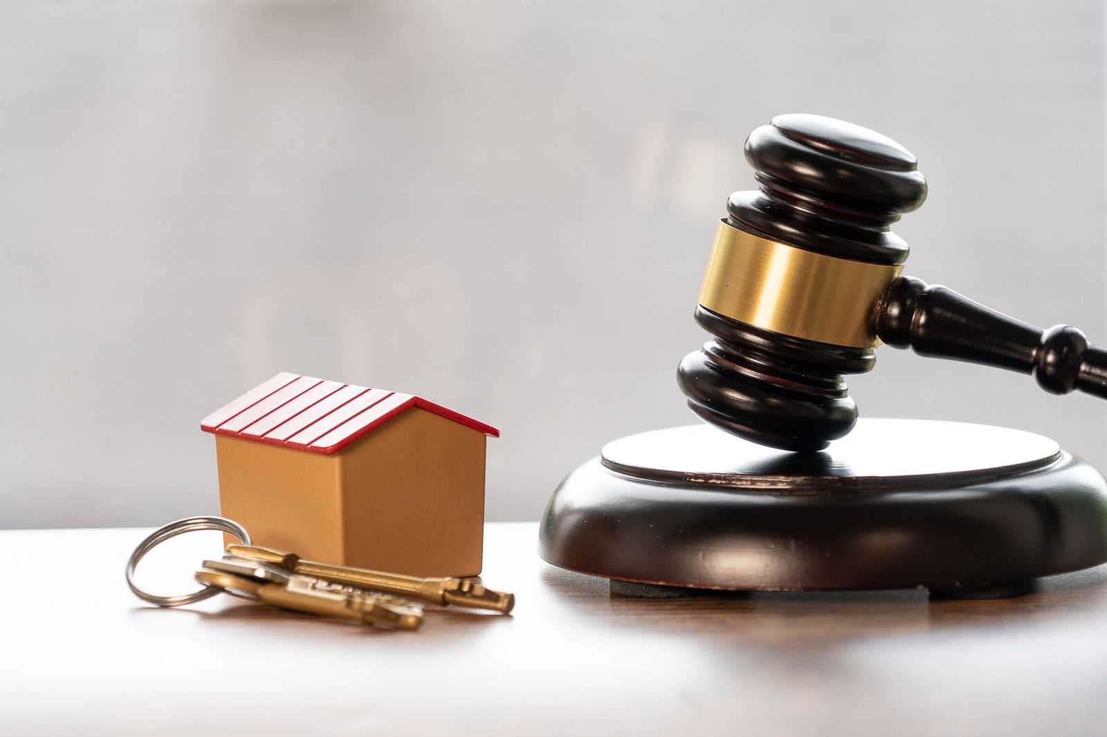 Judge's gavel with house keys, symbolizing court and divorce records that reveal real figures behind net worth claims