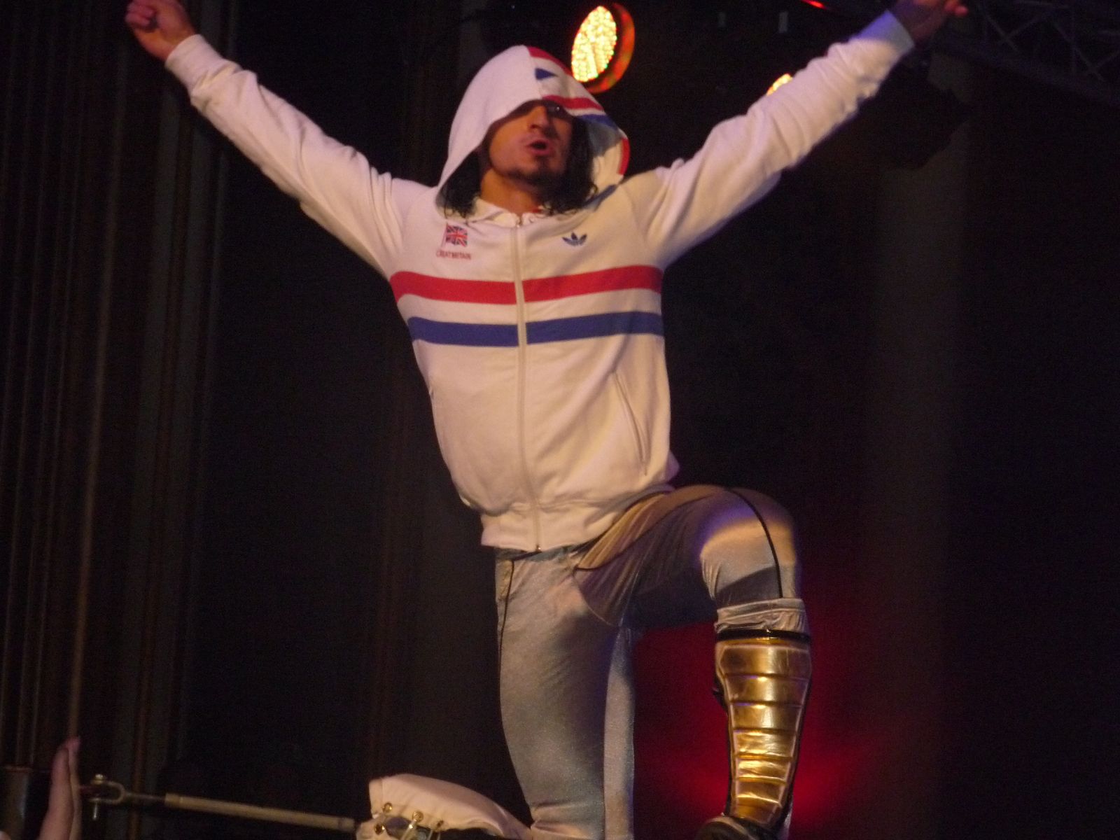 A young Pac posing with arms raised during his early wrestling career