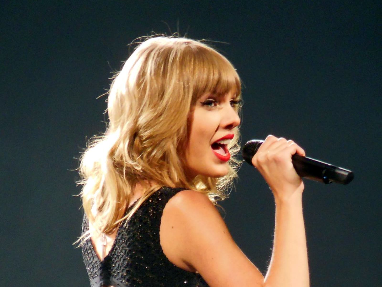 Taylor Swift singing on stage during the Red Tour