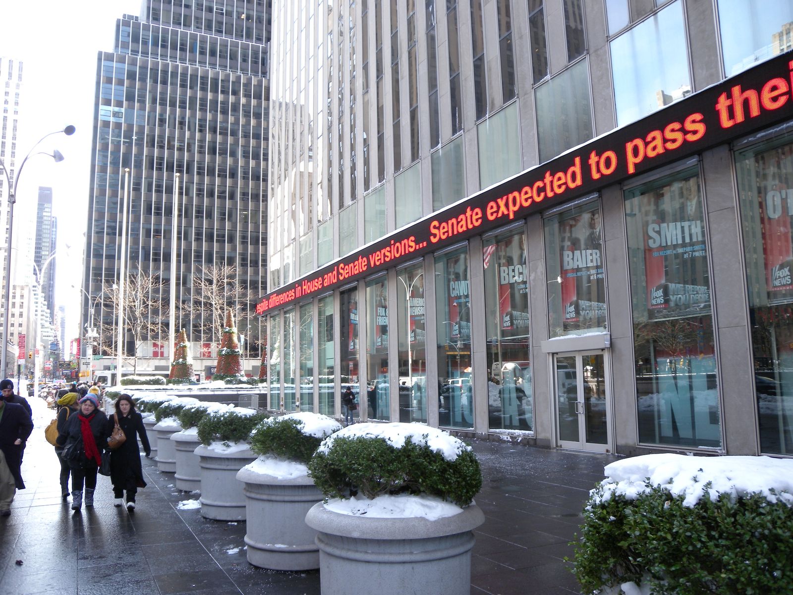 The Fox News Channel building on 6th Avenue in Manhattan on a snowy day, with its news ticker overhead.