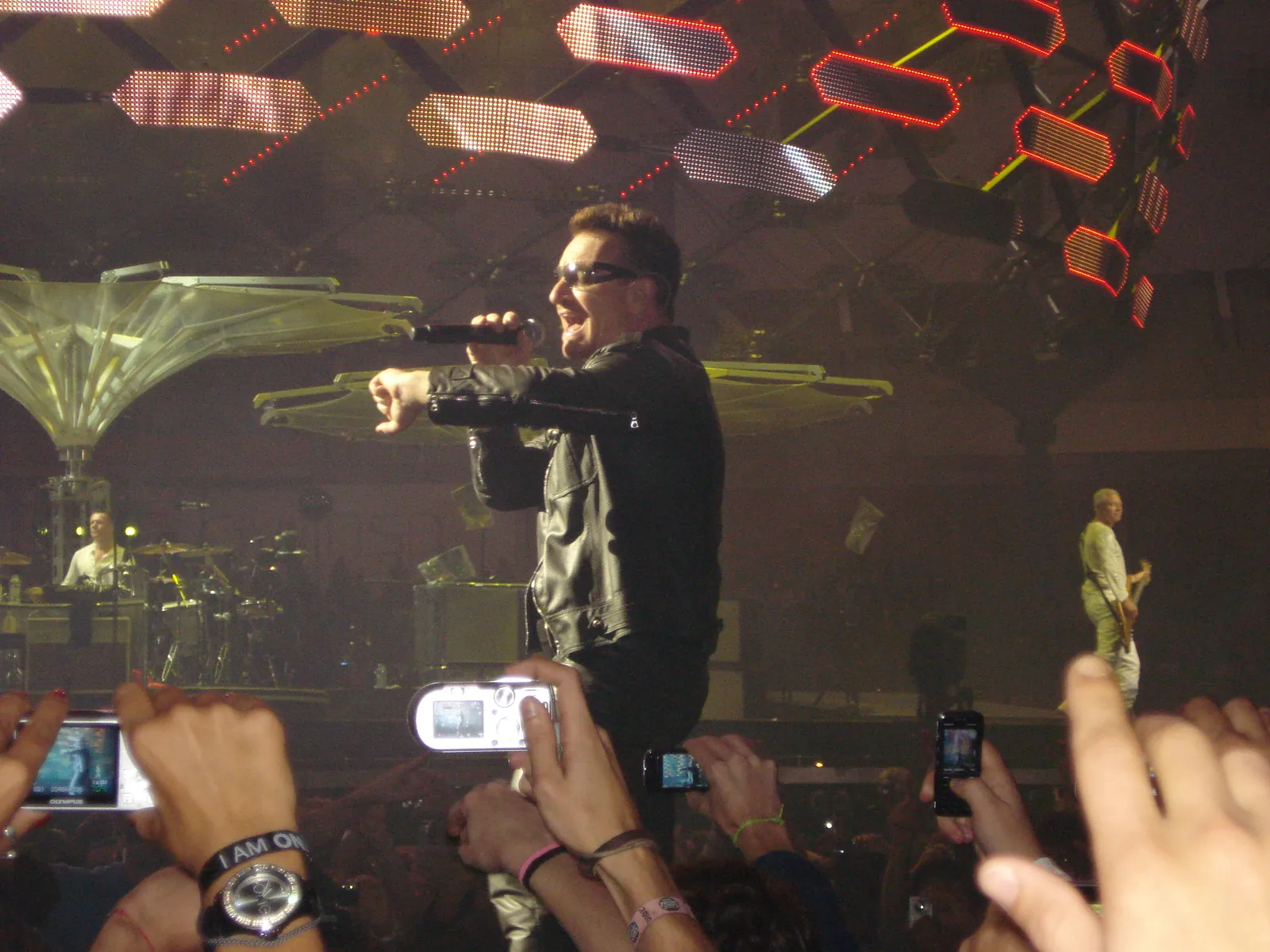 Bono performing live on stage with a microphone