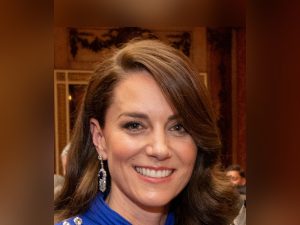 Catherine, Princess of Wales smiling in a blue dress at a Buckingham Palace reception in May 2023.