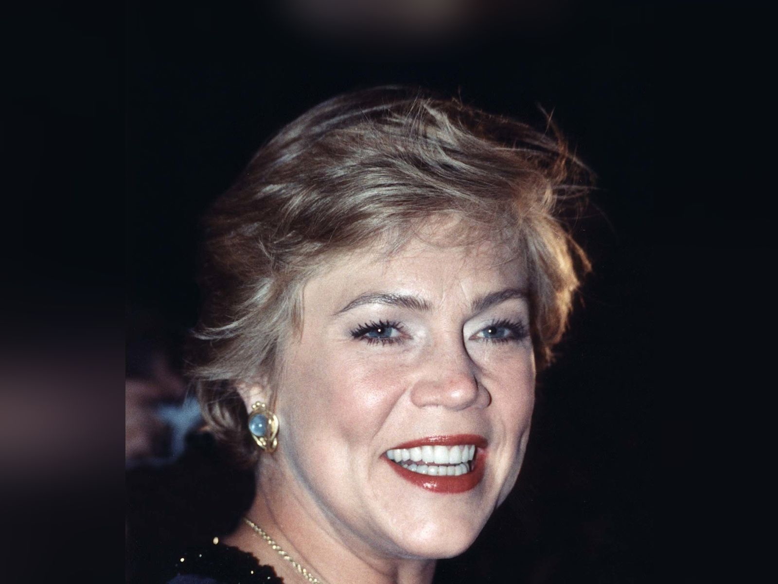 Kathleen Turner smiling at a public event, her full head in frame with clear headroom