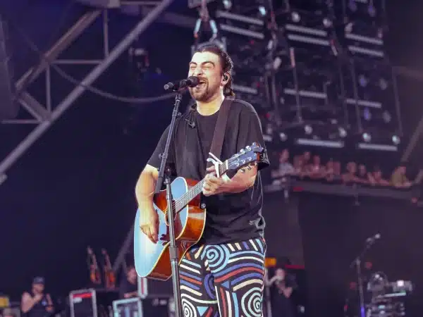 Noah Kahan singing with an acoustic guitar at Glastonbury Festival 2025