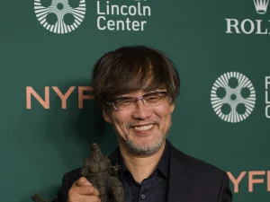 Takashi Yamazaki, writer-director of Godzilla Minus Zero, poses with a Godzilla figure at the New York Film Festival premiere in 2026