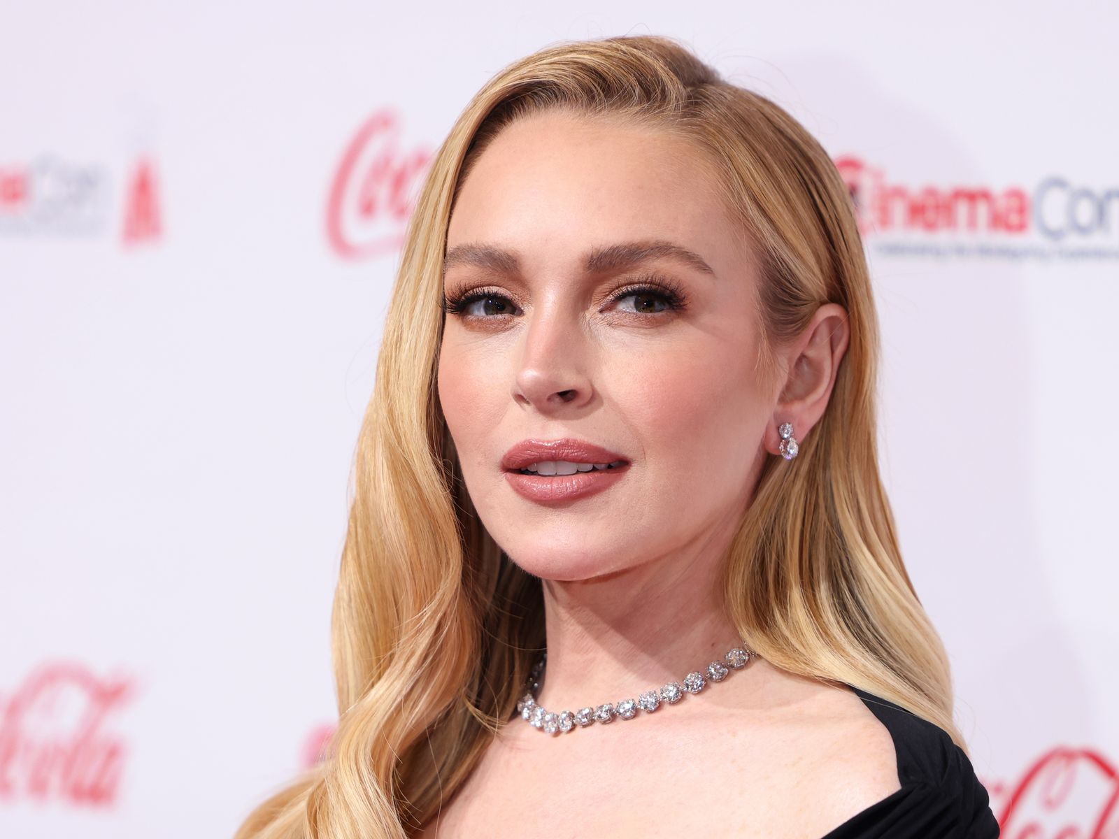 Lindsay Lohan smiling on the red carpet at CinemaCon 2025 in Las Vegas