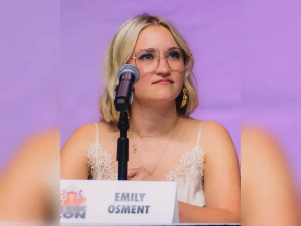 Emily Osment at Los Angeles Comic Con 2025, seated at a panel behind her name placard