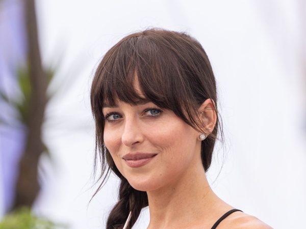 Dakota Johnson smiling at the 2025 Cannes Film Festival photocall
