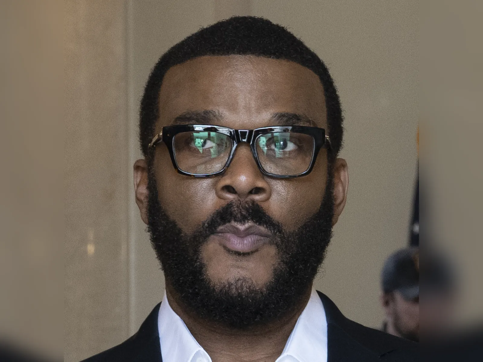 Tyler Perry portrait in 2024 wearing glasses and a suit