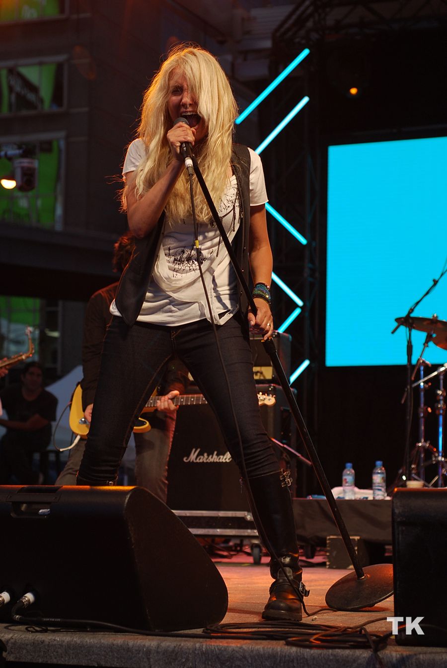 Sass Jordan performing live, hair blowing as she sings into the microphone