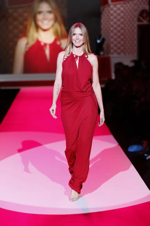 Heidi Klum walking the runway in a red John Galliano gown at The Heart Truth fashion show — a supermodel look from the Heidi Klum Halloween costumes icon