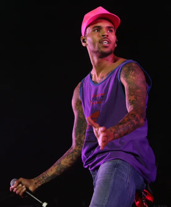 Chris Brown performing on stage at Supafest in Sydney, Australia, in 2012, wearing a pink cap and purple tank top