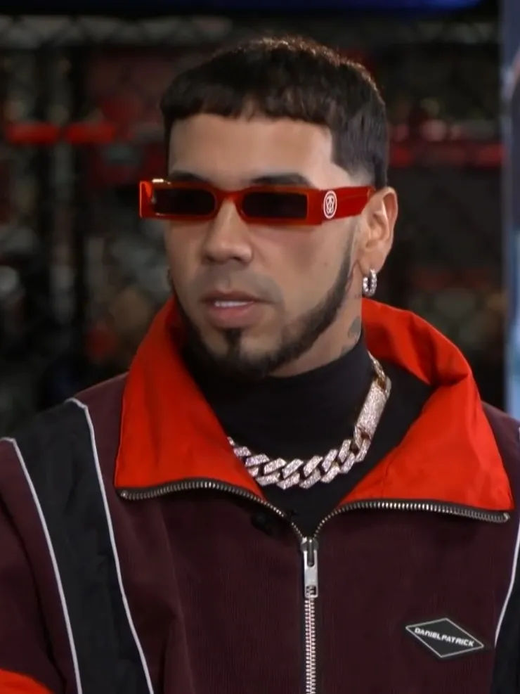 Anuel AA wearing red sunglasses during an interview