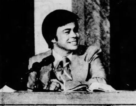 Jim Bakker seated at a PTL Club broadcast desk in 1977