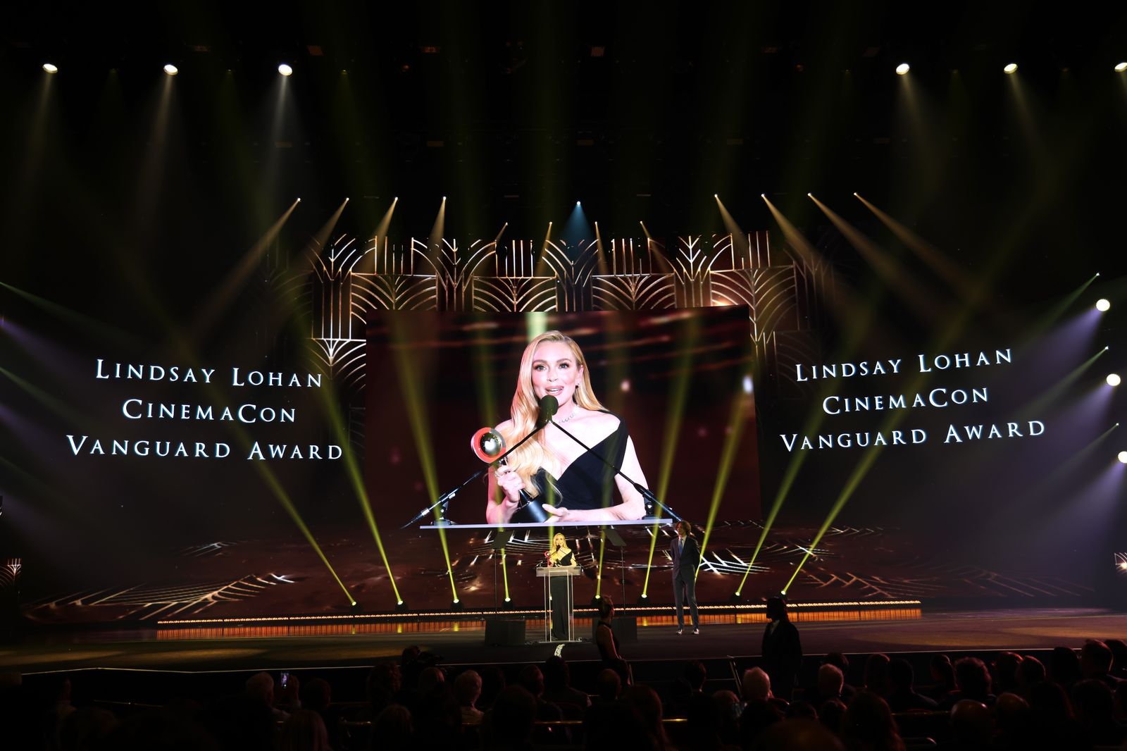 Lindsay Lohan accepting the Vanguard Award on stage at CinemaCon 2025