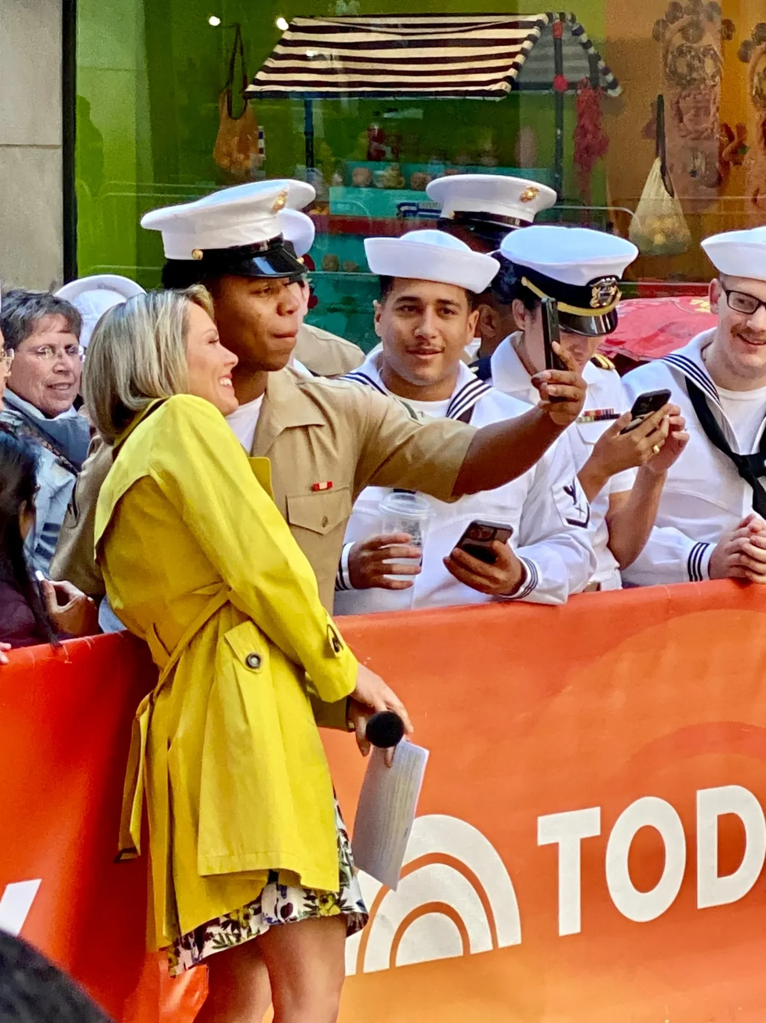 Dylan Dreyer in a yellow coat with service members at the Today Show during Fleet Week New York 2023