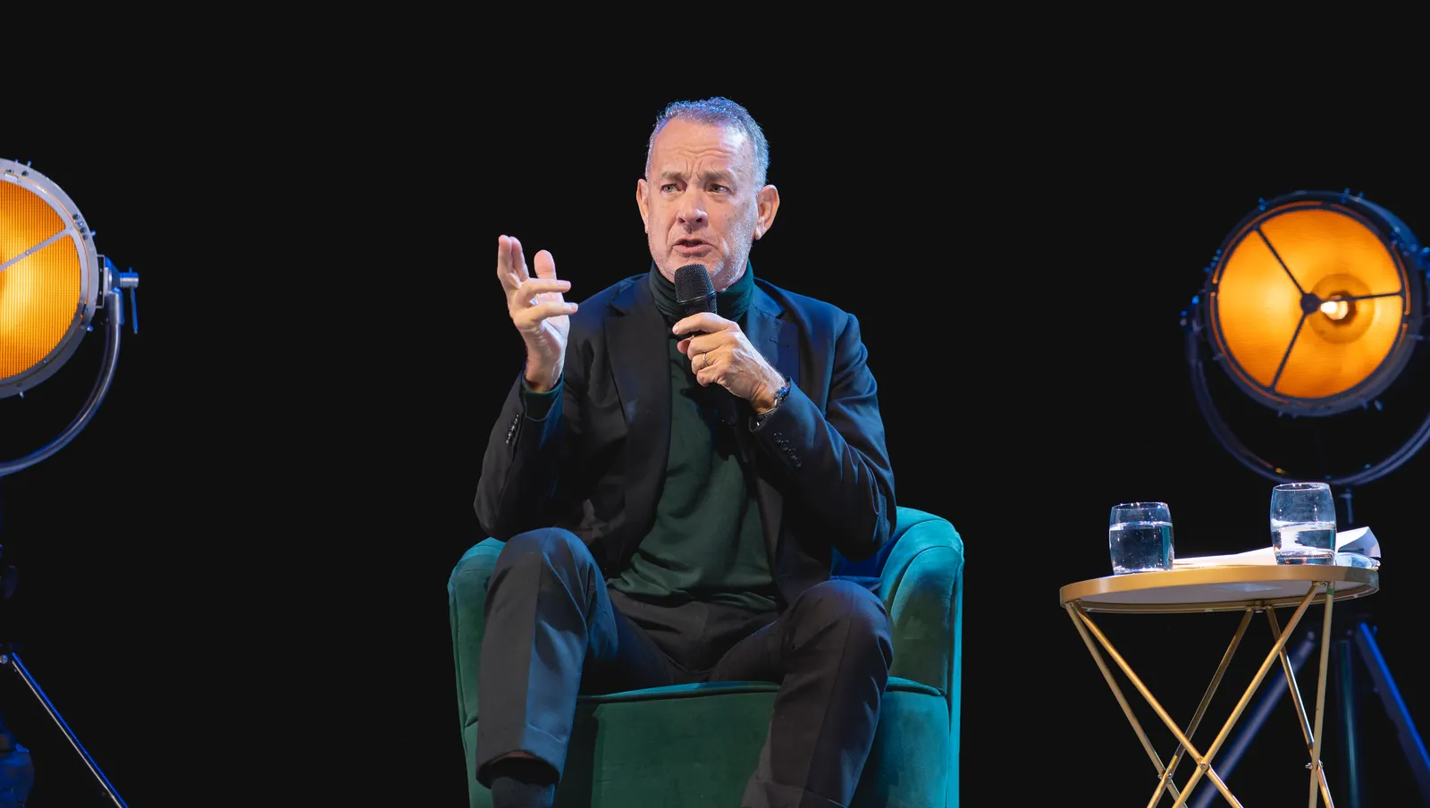 Tom Hanks speaking on stage at the Prince Edward Theatre in London, December 2023