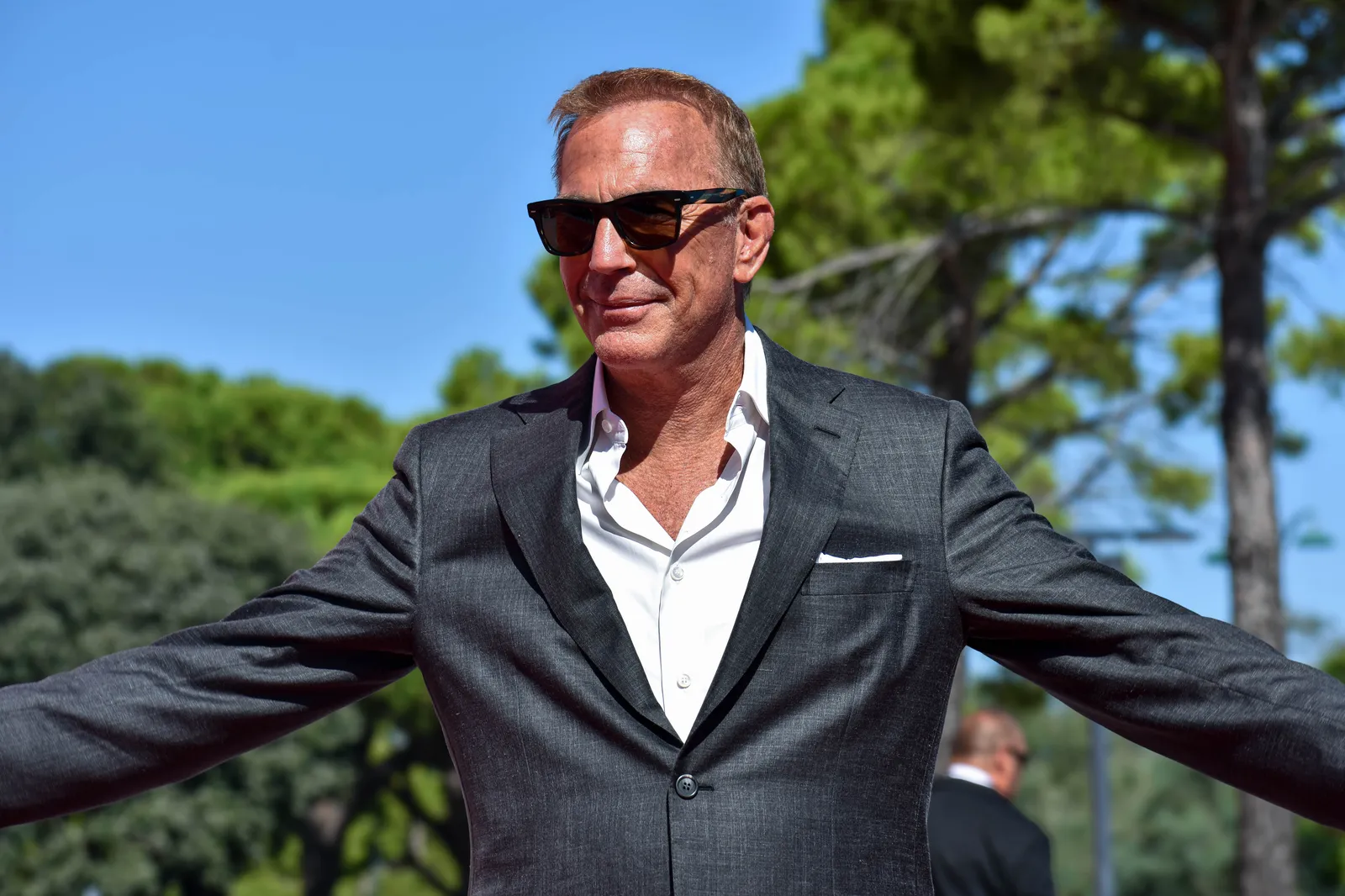 Kevin Costner wearing sunglasses and a dark blazer at the 81st Venice Film Festival in 2024.
