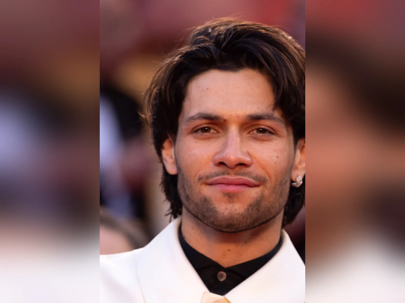 Luke Grimes at the Cannes Film Festival in 2025, smiling in a white jacket on the red carpet.