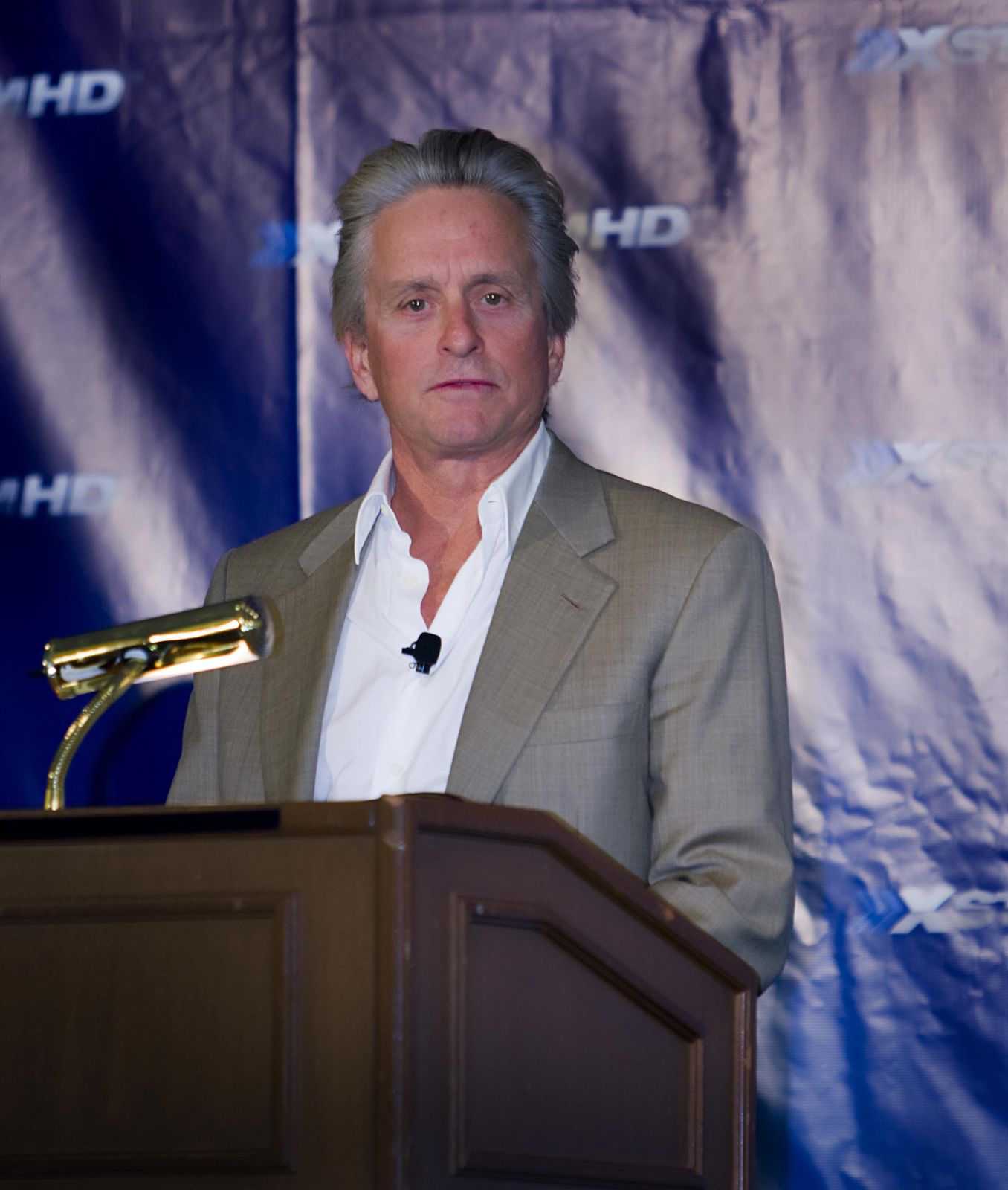 Michael Douglas speaking at a press event, head fully in frame