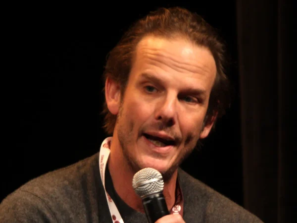 Director Peter Berg speaking into a microphone at a panel discussion