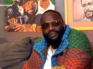 Rick Ross seated wearing a colorful Gucci jacket