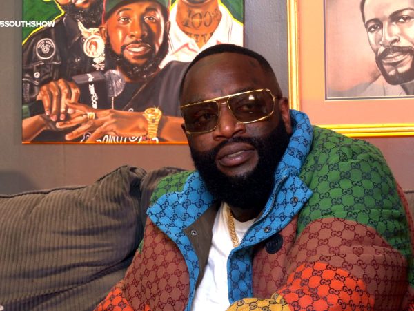 Rick Ross seated wearing a colorful Gucci jacket