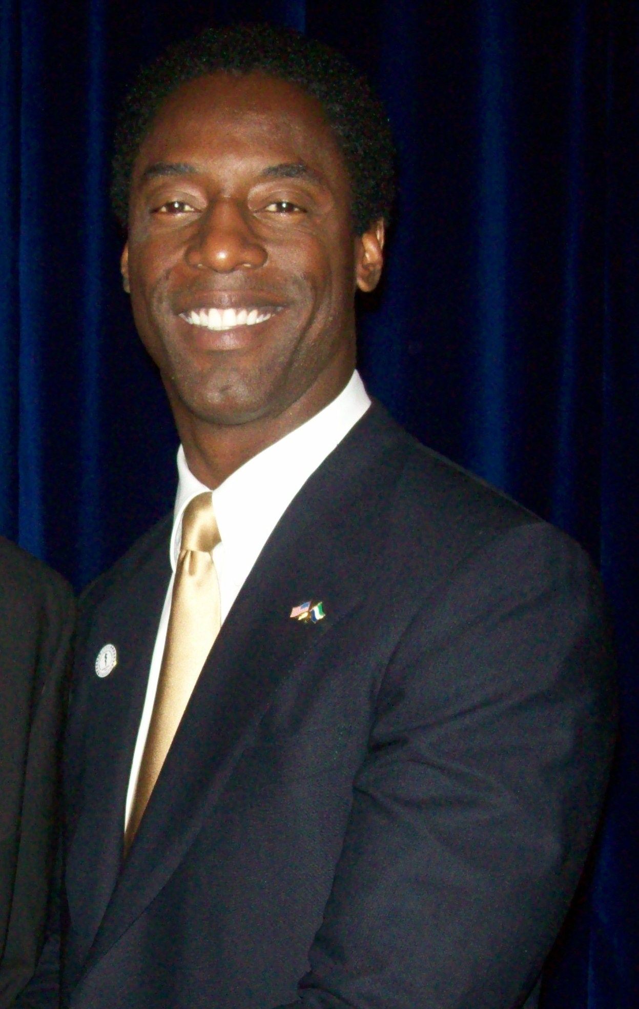 Isaiah Washington smiling in a suit at a formal event