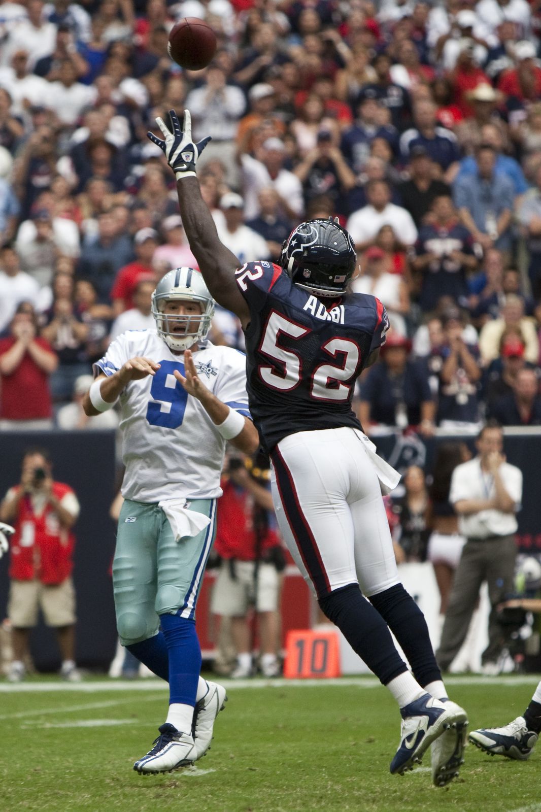 Tony Romo throwing a pass over a Texans defender during an NFL game