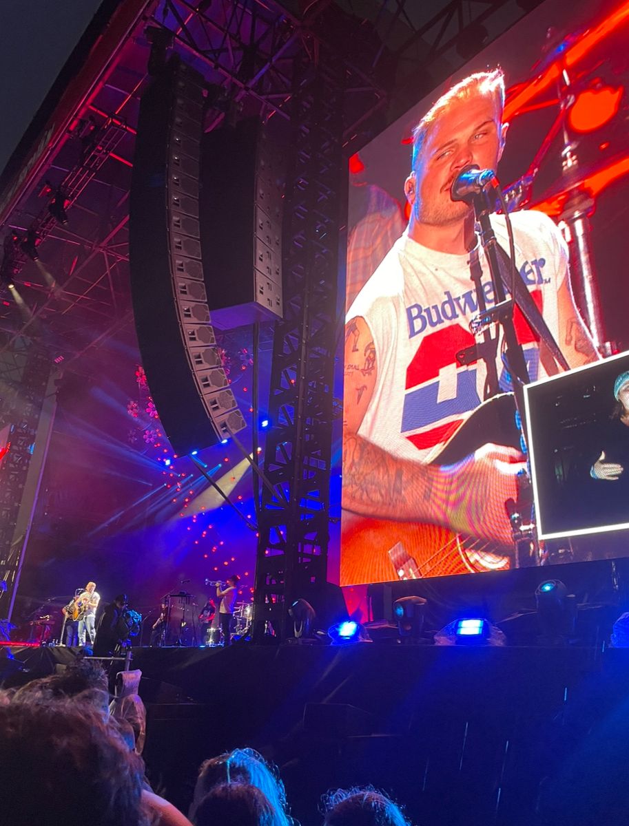 Zach Bryan shown large on a stage screen during a concert at Flemington Racecourse in Melbourne, Australia